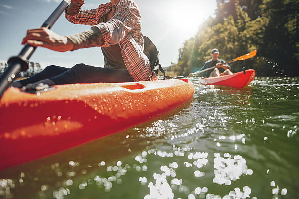 paar kanufahren in einem see auf einem sommertag - kayak canoeing canoe lake stock-fotos und bilder