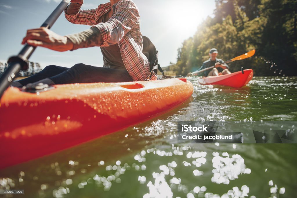 Couple canoeing in a lake on a summer day Cropped image of woman kayaking with a man in background. Couple canoeing in a lake on a summer day. Kayak Stock Photo