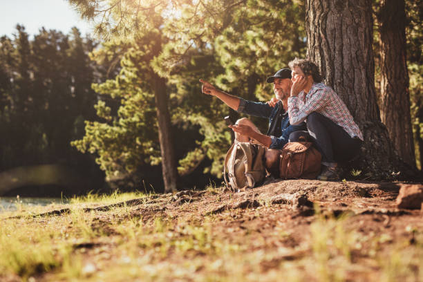 istock Mature sitting near a lake using compass 523861468
