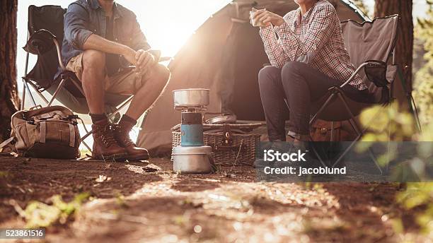 Couple Sitting In Chairs Outside The Tent Stock Photo - Download Image Now - Camping, Cooking, Coffee - Drink