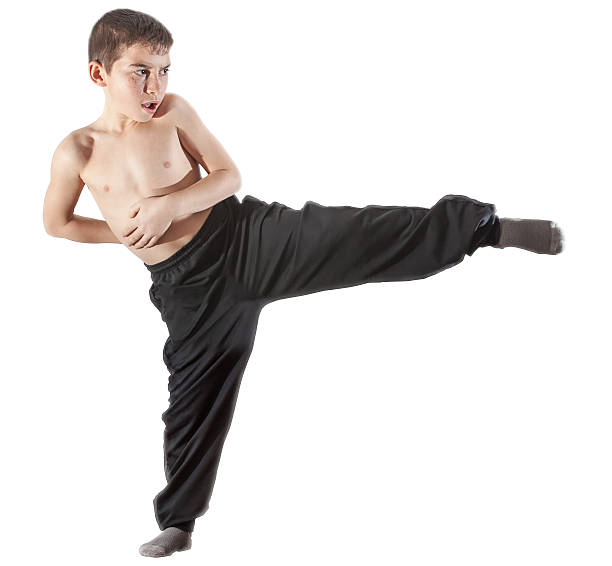 istock young boy doing a kick of karate training 523863060