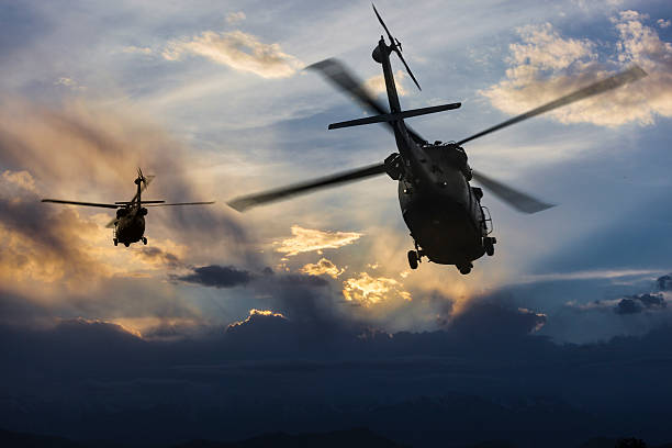 istock Military Helicopters in flight et sunset 523866382