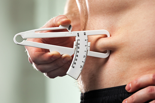 Man Is Measuring His Body Fat With Calipers Stock Photo - Download