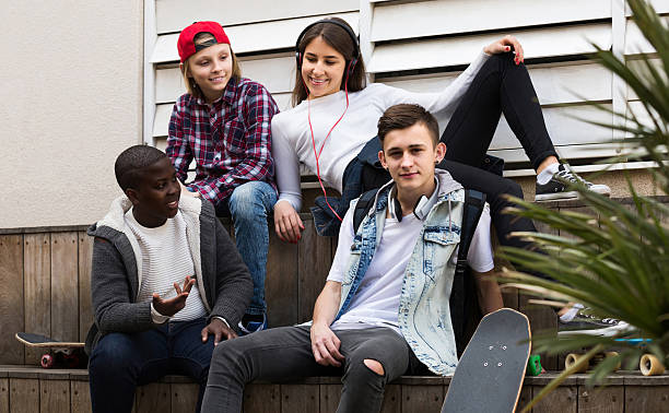istock girl and three boys hanging out outdoors and discussing somethin 523868872