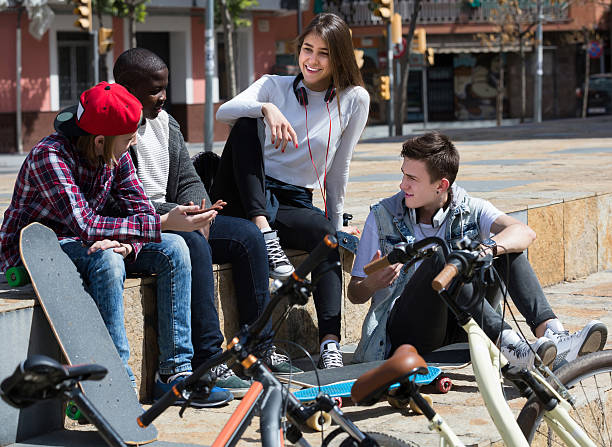 istock girl and three boys hanging out outdoors and discussing somethin 523869104
