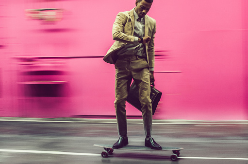 Businessman moving with skateboard by the street, Ljubljana, Slovenia