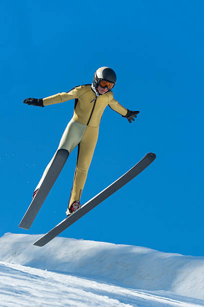 vue de face du jeune homme ski landing à 30 mètres carrés - ski jumping hill photos et images de collection