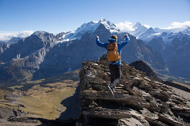 istock Mountaineer leaps between rocks on ridge crest 523872415