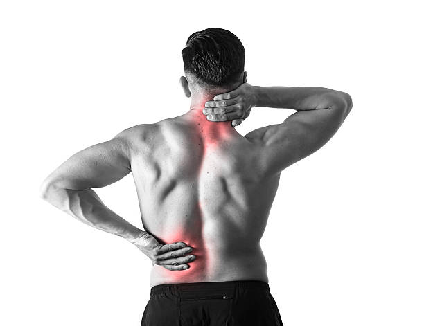 man holding sore neck massaging cervical area suffering body pain back view of young man with muscular body holding his neck and low back suffering pain in sport spinal injury and fitness stress isolated on black and white with red spot sore area cervical vertebrae photos stock pictures, royalty-free photos & images