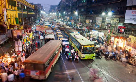 Kolkata, India - January 17, 2013: Dark city traffic blurred in motion at late evening on crowded streets on January 17, 2013 in Calcutta. Kolkata has a density of 814.80 vehicles per km road length