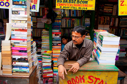 Kolkata, India - January 15, 2013: Asian book seller looking for the customers on the asian street market on January 15, 2013 in Kolkata. From 1976 Kolkata have the Book Fair with 2 million visitors annual