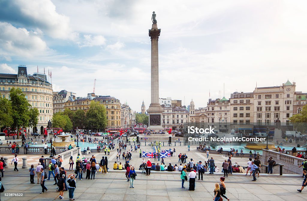 Busy Trafalgar Square London UK on sunny Autumn afternoon Busy Trafalgar Square London UK on sunny Autumn afternoon, with a nutrally occuring crowd of dozens of people, walking, sightseeing or relaxing around the monument. Trafalgar Square Stock Photo