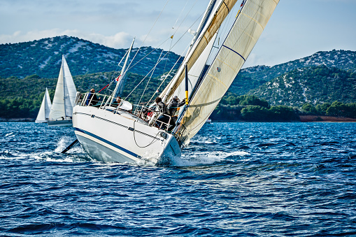 Leading sailing crew of six people on sailboat during regatta on sunny day. All 6 model released. http://santoriniphoto.com/Template-Sailing.jpg