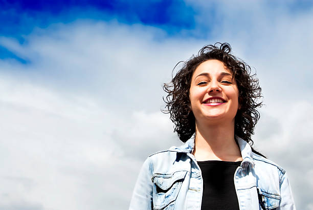 istock Beautiful woman with a sky with clouds background 523885346