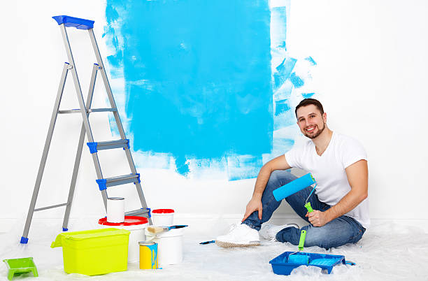 istock happy man doing repairs, paint wall at home 523886060