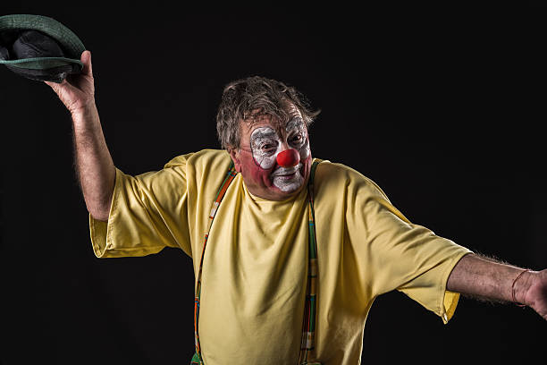 istock old-aged clown on black background 523886470
