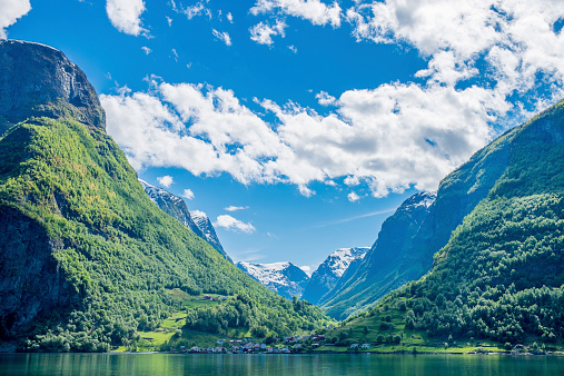 A view of the Sognefjord in Norway with snow capped mountains in the distance.