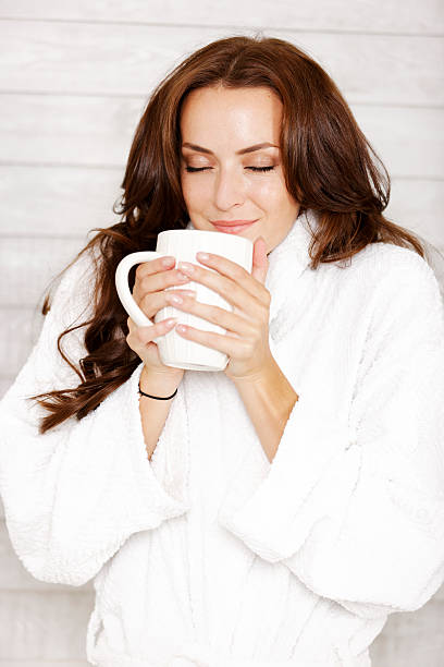 istock Woman in robe enjoying hot drink 523894381