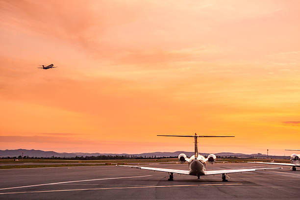 飛行機の夕暮れ - airport airplane landing red ストックフォトと画像