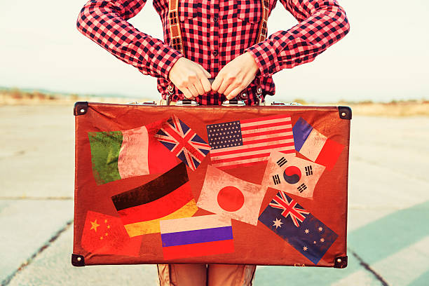 istock Woman holds suitcase with stamps flags 523895841