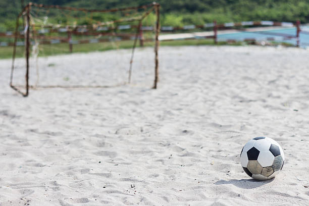 istock football on the white beach 523896263