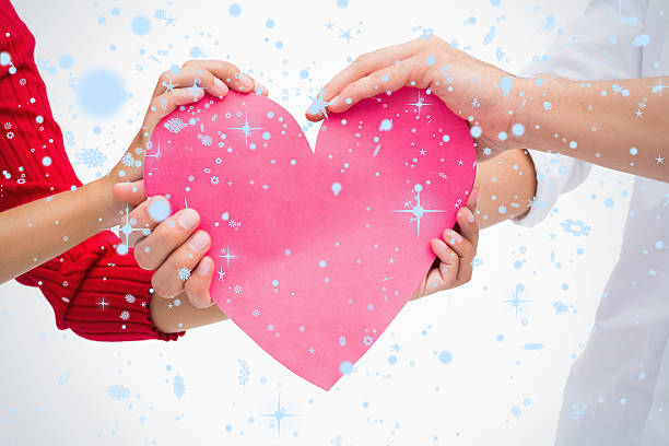 istock Composite image of couples hands holding pink heart 523898049