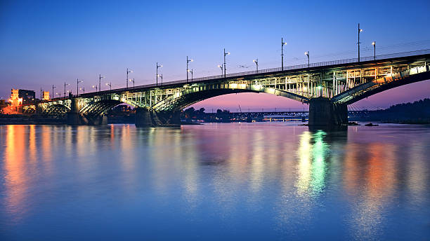 istock Backlit bridge at night and reflected in the water 523965455