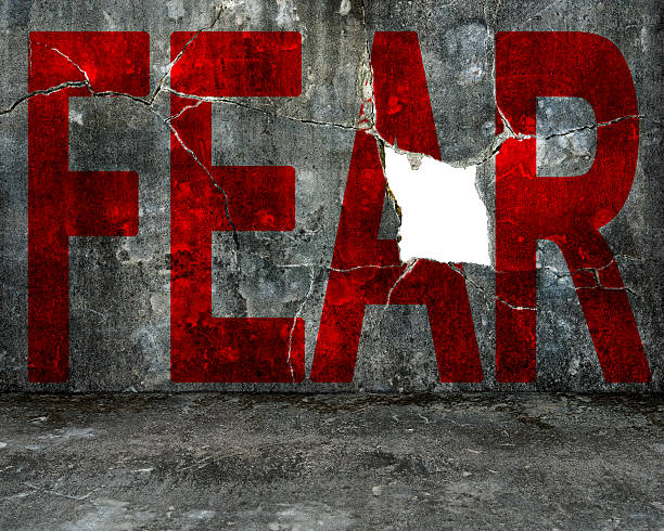 istock red fear word on mottled concrete wall with large hole 523967957