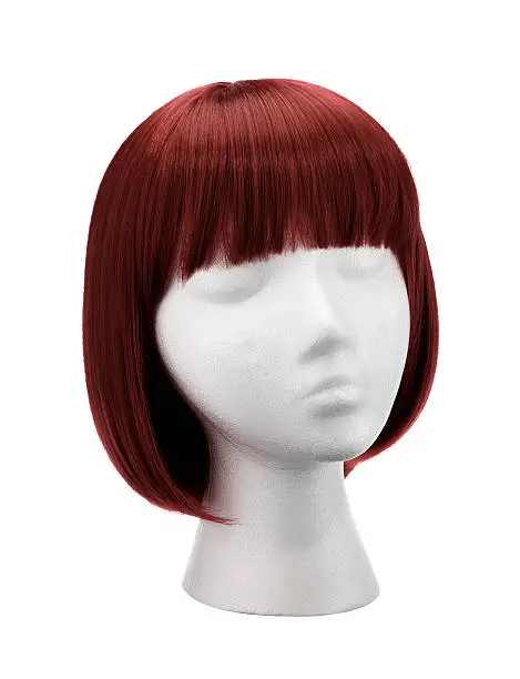 A copper wig with a fringe on a mannequin head, on a white background