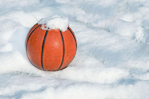 basketball on a playground covered by snow