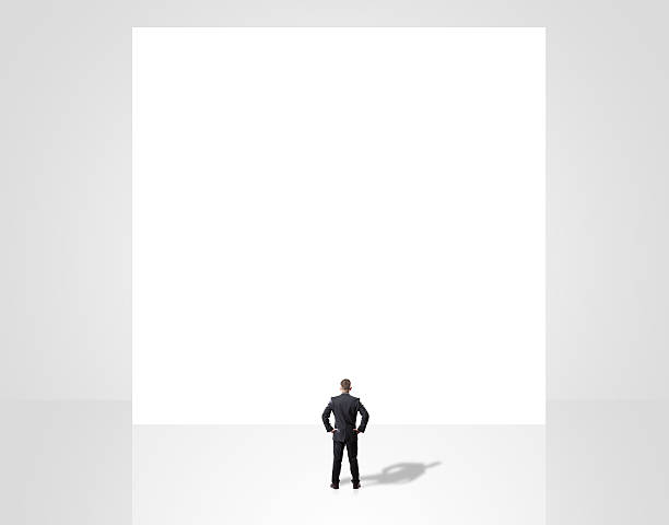istock businessman looking on a white wall 523998349