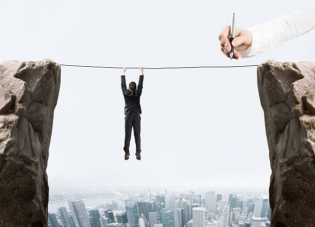 istock hand drawing businessman hanging by a rope and rock 524000363
