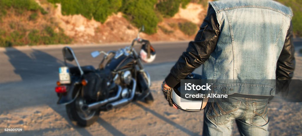 biker and motorcycle on the road biker and motorcycle on the edge of the road at sunset Waistcoat Stock Photo