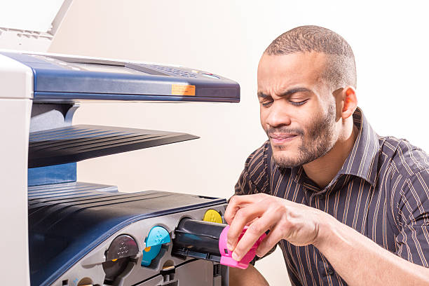 istock doubting african man fixing copier in the office 524008104