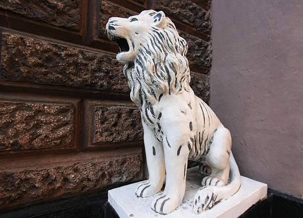 istock Statue of a sitting roaring white lion 524008326