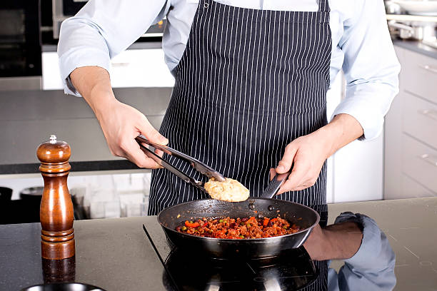 istock Chef preparing dishes in a frying pan 524008512