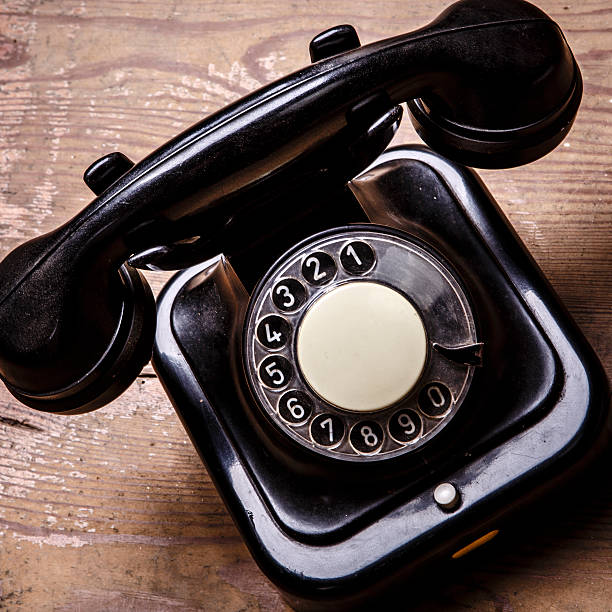 istock Old black phone with dust and scratches on white background 524009362
