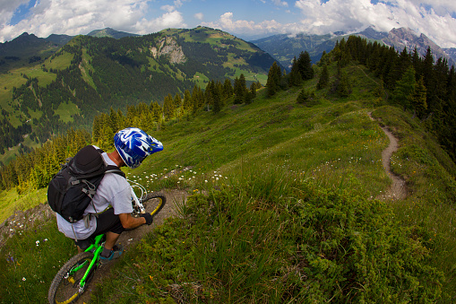 A male mountain biker ride a singletrack downhill trail in Switzerland.