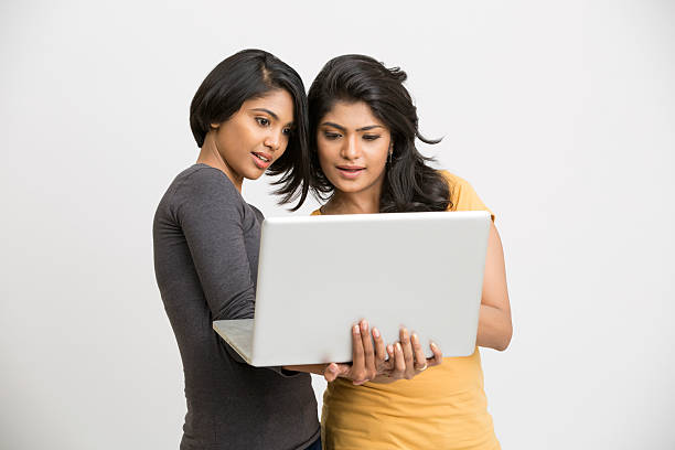istock Pretty young girls looking at laptop and discuss something 524014366