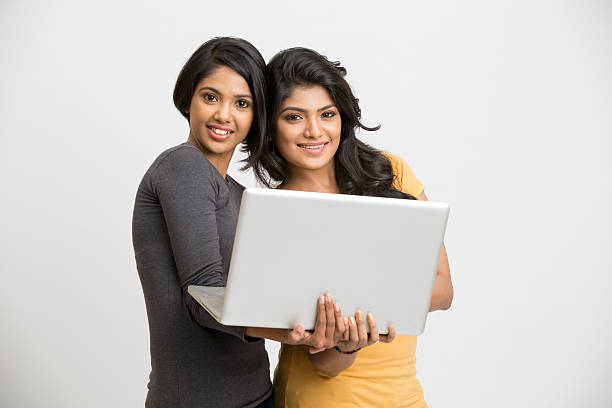 istock Happy young girls posing with laptop 524014466