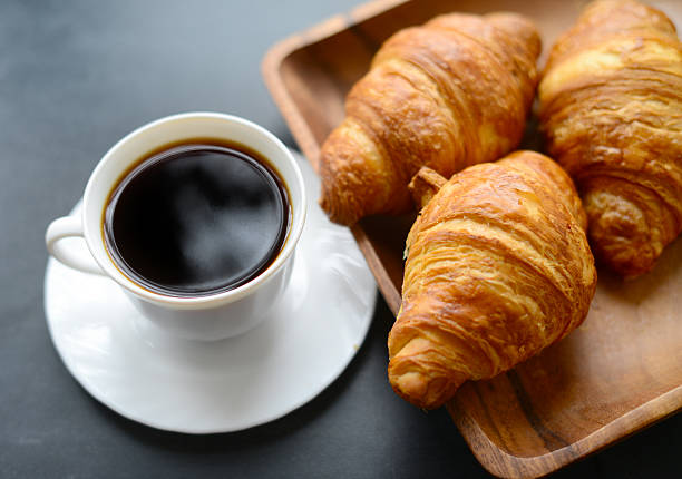 istock cup of coffee and croissants on black background 524015464