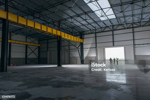 Architect Team At Work Site With Blueprints Stock Photo - Download Image Now - Warehouse, Empty, Industrial Building