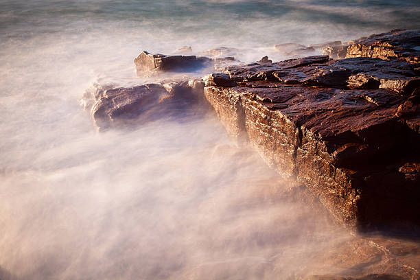 istock Abstract view of waves crashing onto rocks. 524018458
