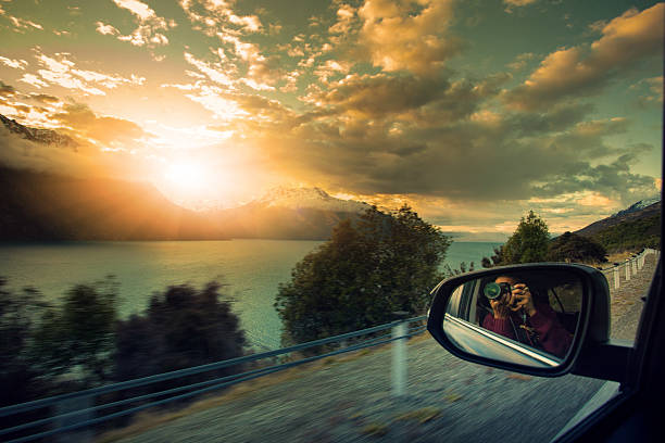 Reflection of nature overcast forest landscape in window of the traveling car on the mountain road on high speed moving