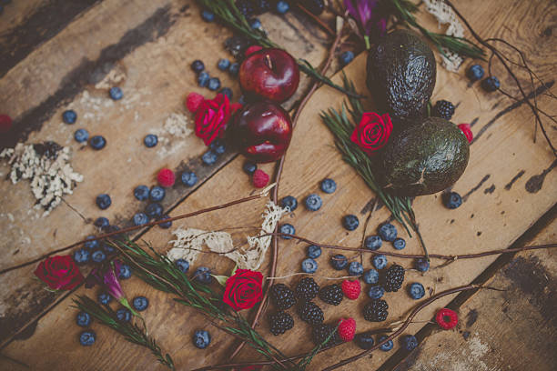Berries, plums and avocados on barnwood