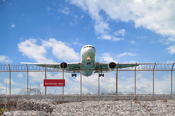 istock Restricted area fence  and Passenger airplane landing. 524024484