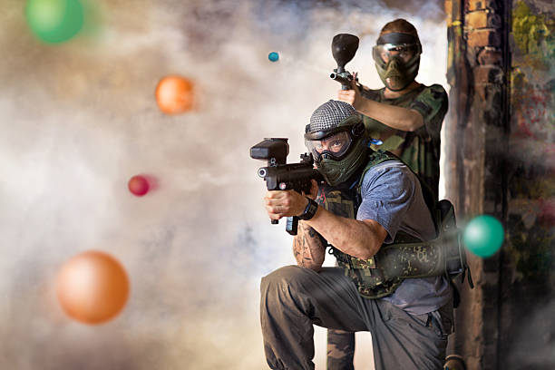 Play paintball game Play paintball game, two player with guns paintballing stock pictures, royalty-free photos & images