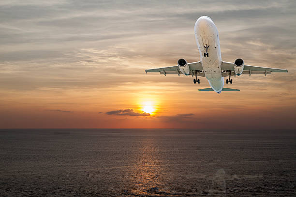 istock Airplane flying tropical sea at sunset time with reflection 524024682