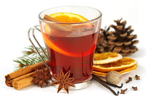 glass of mulled wine and spices on white background
