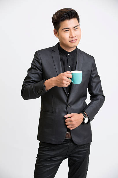 Young businessman with coffee cup on white background.